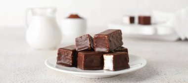 Işık masasında lezzetli kuş sütü şekerlemeli tabak.