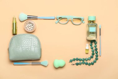 Makyaj ürünleri ve bej arka planda aksesuarlarla kozmetik çantadan yapılmış çerçeve