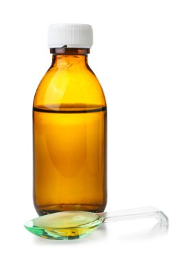 Bir şişe öksürük şurubu ve beyaz arka planda kaşık.