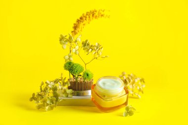 Sarı arkaplanlı bir kavanoz krema.