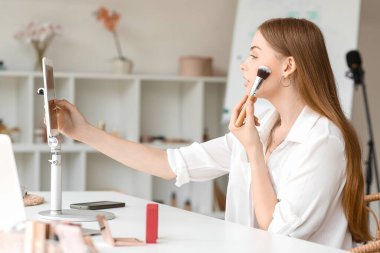 Kadın güzellik blogcusu soyunma odasında video kaydederken toz uyguluyor