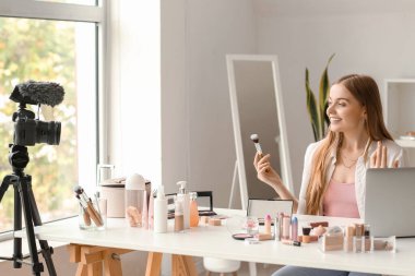 Makyaj fırçası ile giyinme odasında video kaydeden kadın güzellik blogcusu