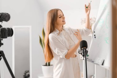 Genç güzellik blogcusu panoya resim çizerken evde video kaydediyor