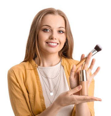 Makyaj temeli olan ve beyaz arka planı fırçalayan genç bir güzellik blogcusu