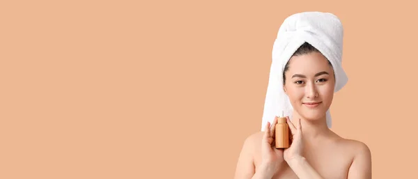 Genç Asyalı Kadın Bej Arka Planda Bir Şişe Kozmetik Serumu — Stok fotoğraf