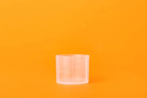 橙色背景下的空量杯 — 图库照片