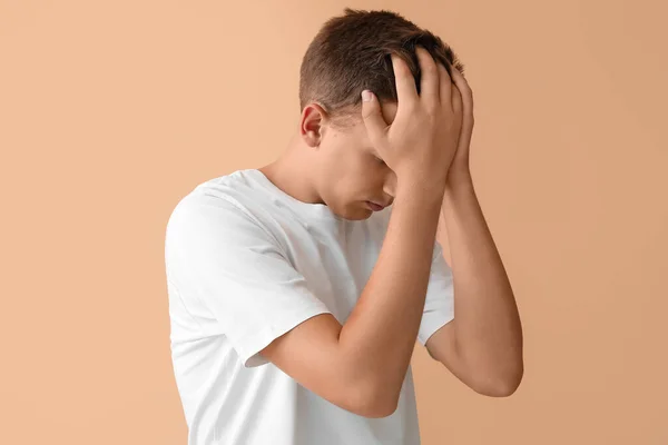 Stressed young man on beige background