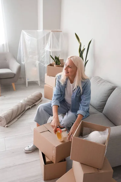 Mature Woman Taping Cardboard Box Living Room Moving Day — Stock Photo, Image