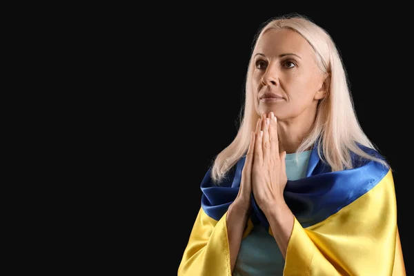 Dojrzała Kobieta Flagą Ukrainy Modli Się Czarnym Tle — Zdjęcie stockowe