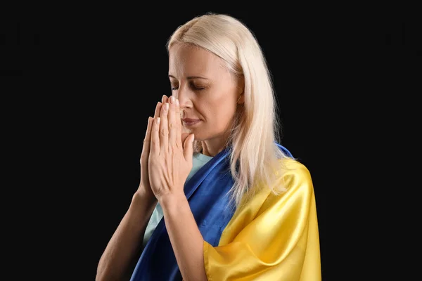 Dojrzała Kobieta Flagą Ukrainy Modli Się Czarnym Tle — Zdjęcie stockowe