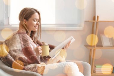 Evde çay fincanı okuyan güzel bir kadın.