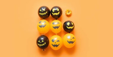 Komik Cadılar Bayramı balonları ve turuncu arka planda balkabağı, üst manzara