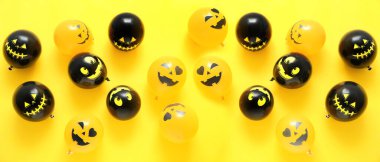 Sarı arka planda bir sürü komik Cadılar Bayramı balonu