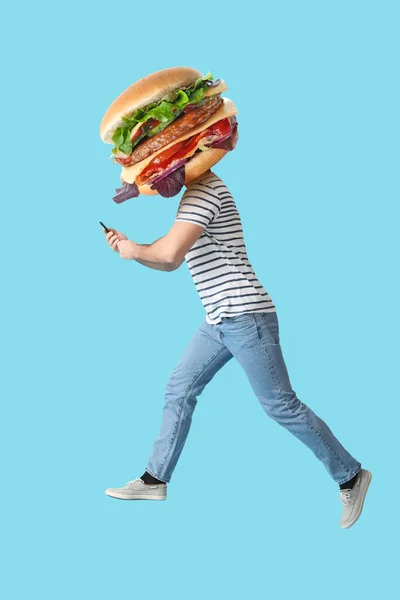 Jumping Man Tasty Burger Instead His Head Smartphone Light Blue — Stock Photo, Image