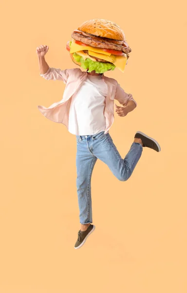 Springender Mann Mit Leckerem Burger Statt Kopf Auf Beigem Hintergrund — Stockfoto