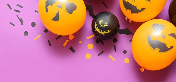 Funny Halloween balloons on lilac background with space for text