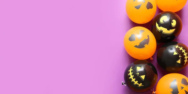 Funny Halloween balloons on lilac background with space for text