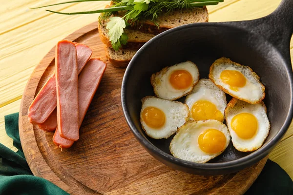 平底锅里放满了美味的炸鹌鹑蛋和香肠 配以彩色木制背景 特写镜头 — 图库照片