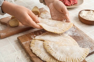 Bej karo arka planda chebureks hazırlayan kadın, yakın plan