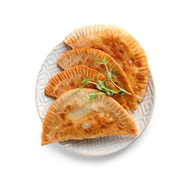 Beyaz arka planda lezzetli chebureks ve lahanalı tabak