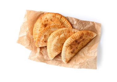 Beyaz arkaplanda lezzetli cheburekler bulunan fırın kağıdı