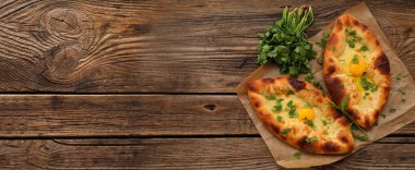 Ahşap zemin üzerinde bitkiler ve metin için yeri olan lezzetli Ajarian khachapuri.