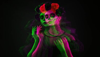 Meksika Ölüler Günü 'nde (El Dia de Muertos) yüzünde boyalı kafatası olan genç bir kadın siyah arka plana karşı 