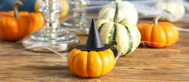 Ahşap masadaki cadı şapkalı Cadılar Bayramı kabağı