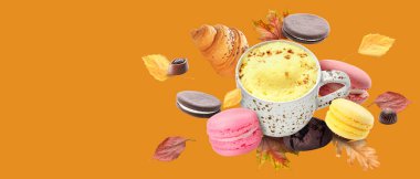 Bir fincan sıcak kahve, tatlı ve sonbahar yaprakları turuncu arka planda mesaj için yer var.