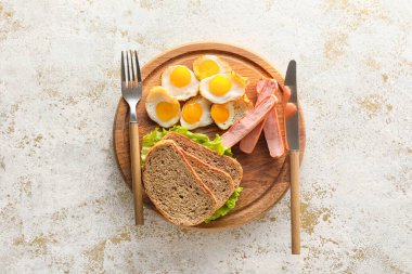 Hafif arka planda kızarmış bıldırcın yumurtası, ekmek ve sosis ile ahşap tahta tahta.