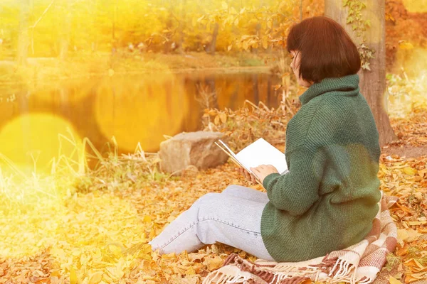 Kobieta Siedząca Kratę Czytająca Książkę Pobliżu Stawu Pięknym Jesiennym Parku — Zdjęcie stockowe