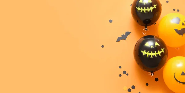 Halloween balloons on orange background with space for text