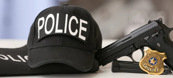 Uniform of policeman with gun on table, closeup