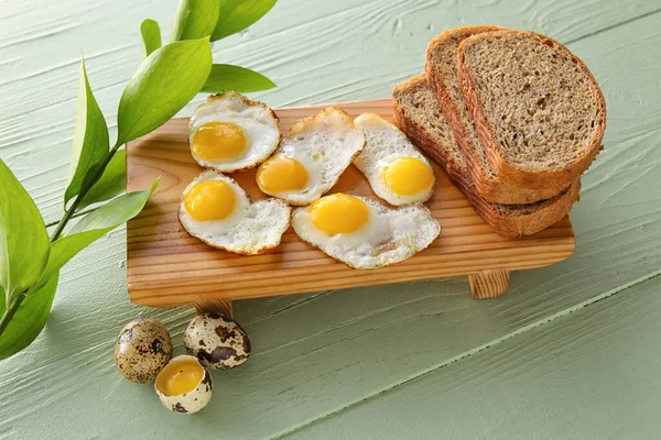 配以美味的鹌鹑蛋和彩色木制背景面包的木板 — 图库照片