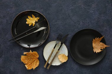 Koyu arkaplanda düşen yapraklarla sonbahar masa ayarları