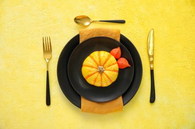 Sarı zemin üzerinde taze balkabağı olan sonbahar masası ayarı