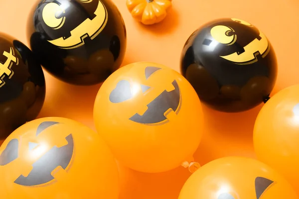 Funny Halloween balloons on color background, closeup