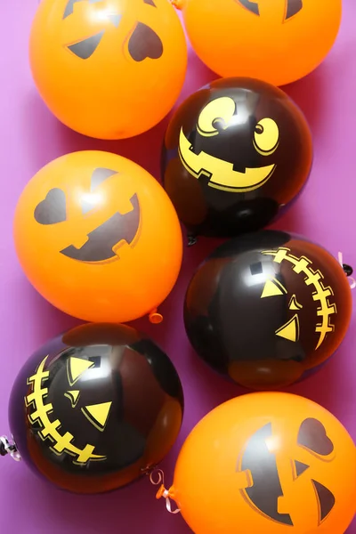 Funny Halloween balloons on lilac background