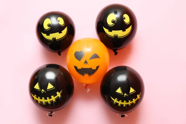 Funny Halloween balloons on pink background