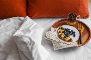Lezzetli kruvasan ve yatakta bir fincan kahve.