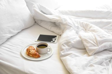 Lezzetli kahvaltı tabağı, tablet bilgisayar ve kulaklık.