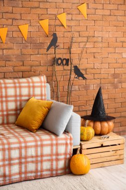 Cadılar Bayramı için kanepe, kutu ve balkabağıyla dekore edilmiş oturma odasının içi.