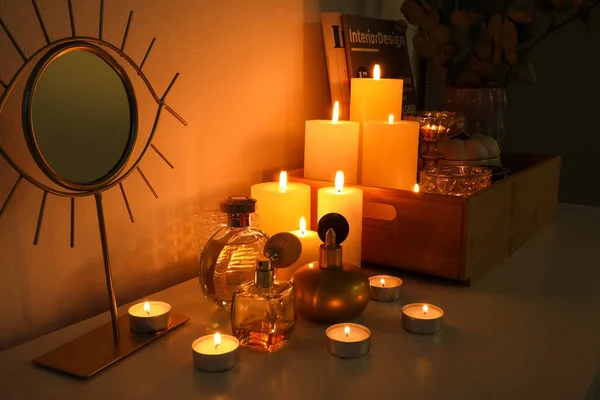 Μπουκάλια Αρώματος Αναμμένα Κεριά Και Καθρέφτη Στο Ράφι Στο Σκοτεινό — Φωτογραφία Αρχείου