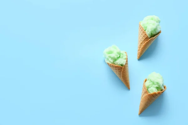 Waffle cones with sweet cotton candy on blue background