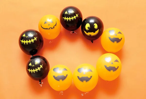 Frame made of Halloween balloons on color background