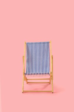 Pembe arka planda plaj sandalyesi