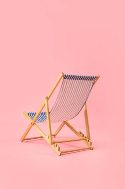 Pembe arka planda plaj sandalyesi