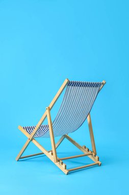 Açık mavi arkaplanda plaj sandalyesi