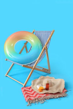 Açık mavi arka planda güverte koltuğu ve plaj aksesuarları