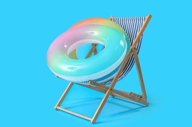 Güverte sandalyesi ve açık mavi zemin üzerinde şişirilebilir halkalar